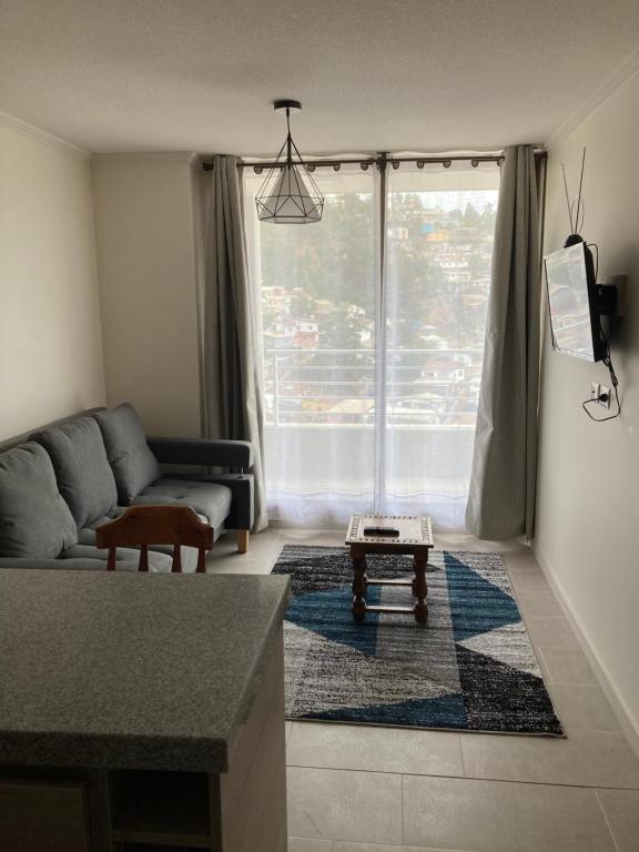 a living room with a couch and a large window at Departamento min 3 noches 3 pers Viña del Mar in Viña del Mar