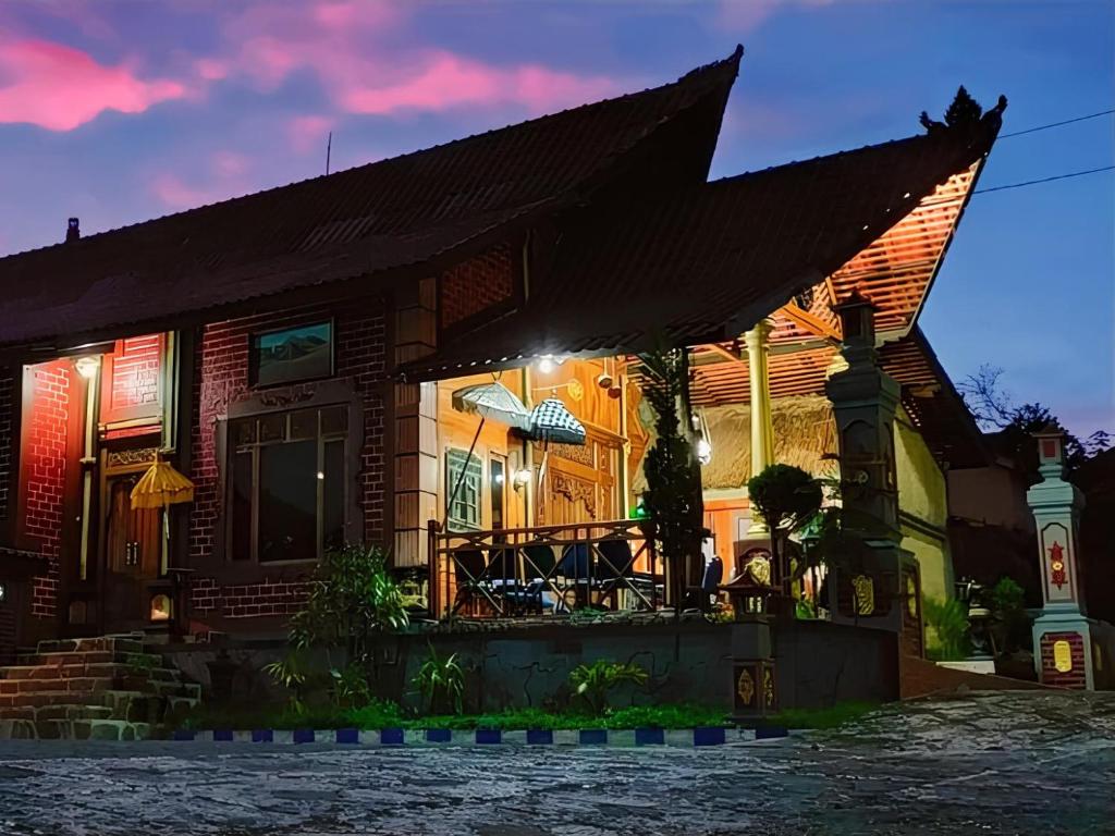una casa con porche por la noche en Yoschi's Hotel Bromo, en Ngadisari