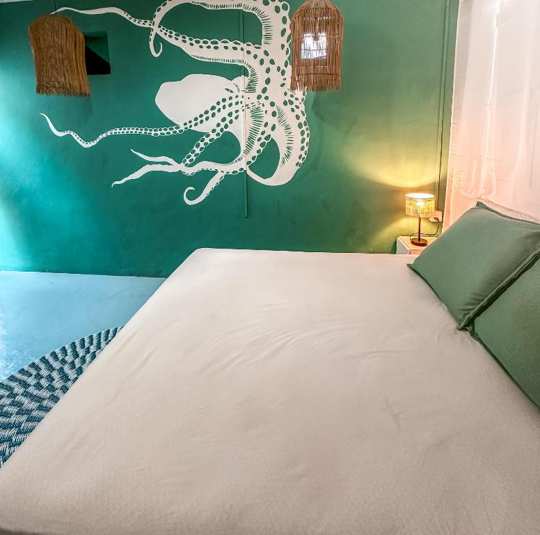 a bedroom with a bed with an octopus on the wall at La villa detente - Une experience authentique in Rodrigues Island