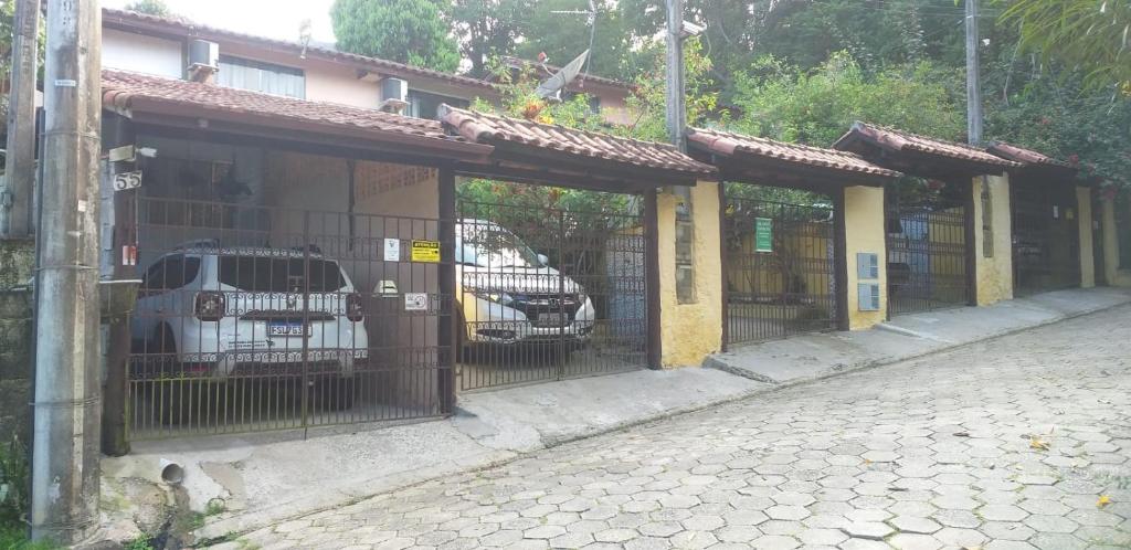 une clôture avec des voitures garées à l'intérieur d'un bâtiment dans l'établissement Casinhas na Praia do Julião em Ilhabela SP, à Ilhabela