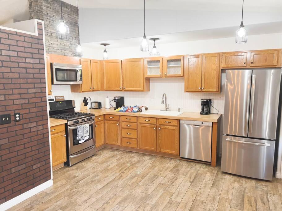 a kitchen with wooden cabinets and stainless steel appliances at Enjoy Fruits Of Your Labours At Grape Dr- View 3D in Las Vegas
