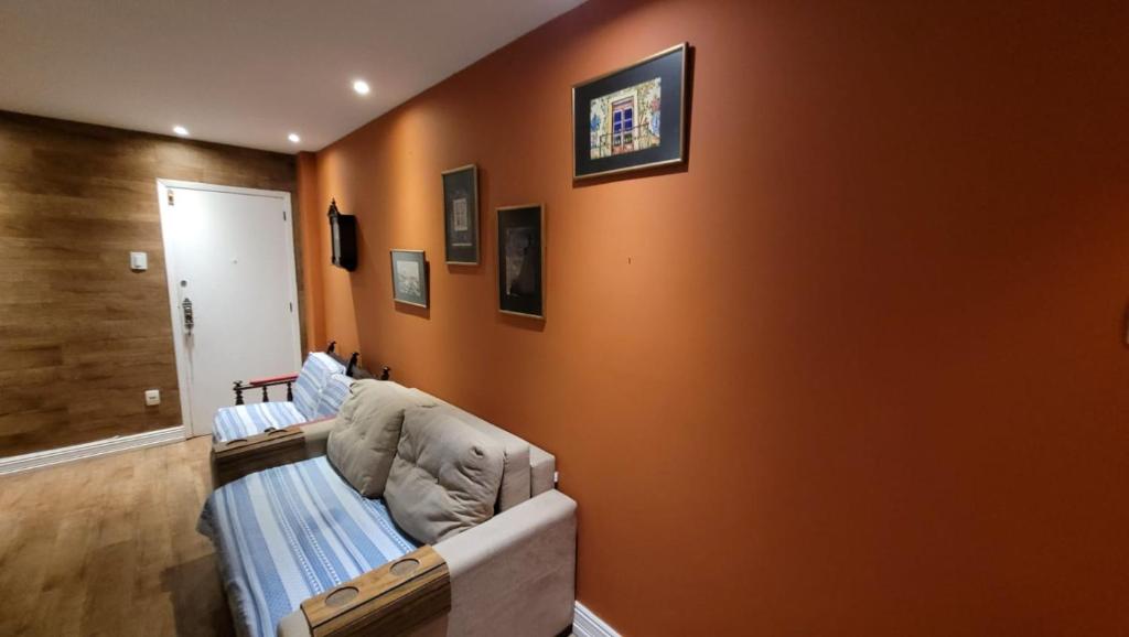 a living room with orange walls and a couch at Copa Lido Apartment in Rio de Janeiro