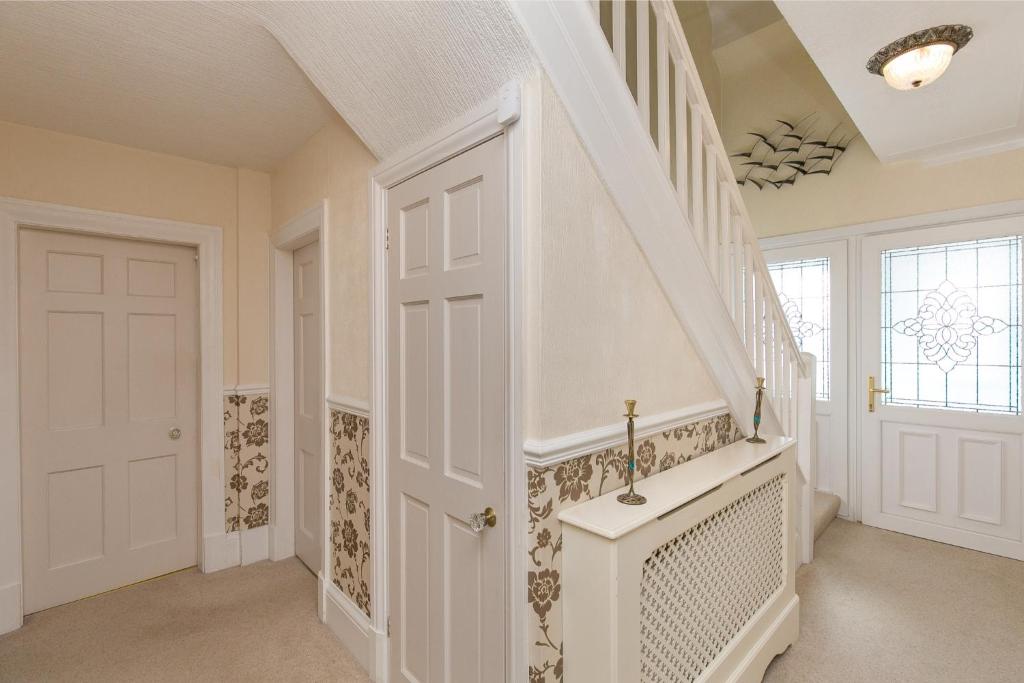 a staircase in a home with a white door at The Cottage on the Beach - Sleeps 7 - Large Garden in Penrhyn Bay