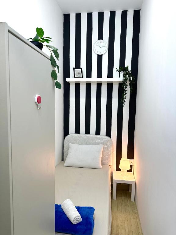 Postel nebo postele na pokoji v ubytování Striped Partition Room in Barsha 1 Near Mall of the Emirates