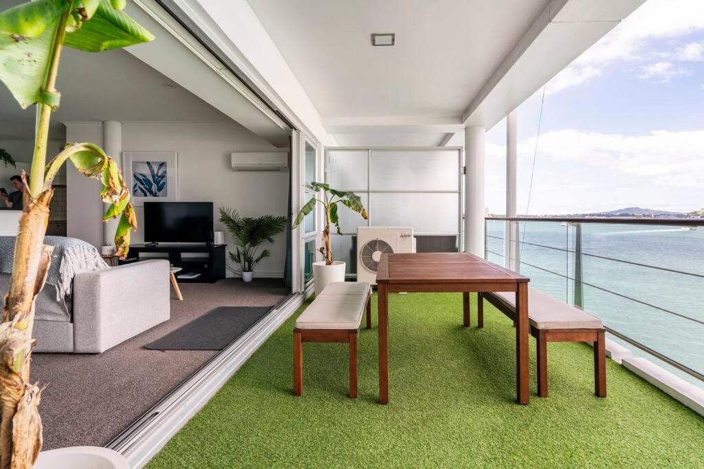 - un salon avec une table et une vue sur l'océan dans l'établissement Luxury Apartment With Stunning Harbour & City View, à Auckland