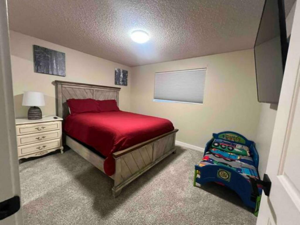 a bedroom with a red bed and a childs toy at Photo Op with Sasquatch 2 min to walk Silver Mtn in Kellogg
