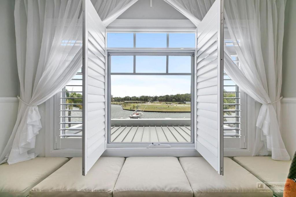 una camera con finestra affacciata sull'acqua di New Haven - Grand Canal View Suite a Banksia Beach