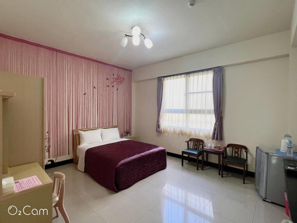 a hotel room with a bed and a table at Swallow Home in Hengchun South Gate