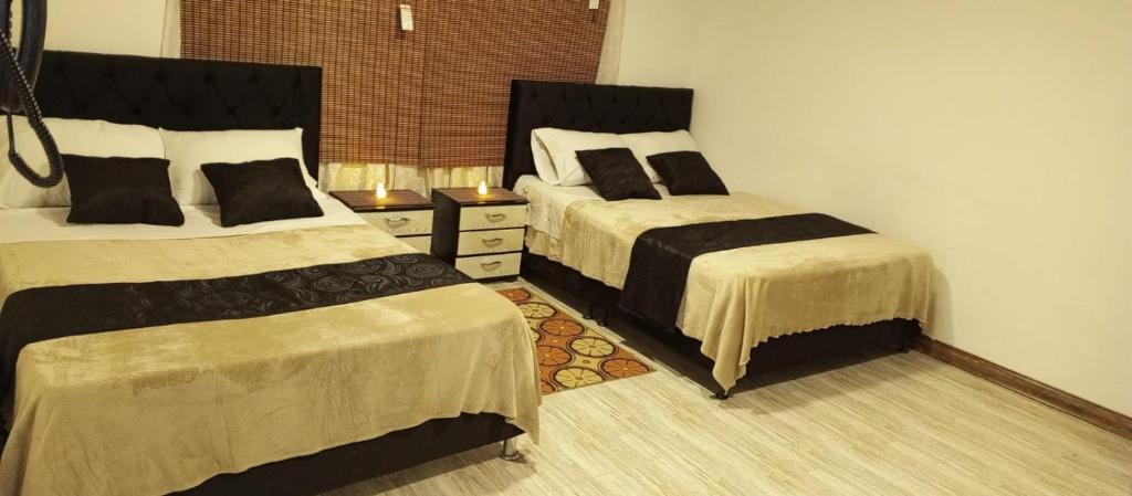 Hotel Palo Grande في مانيزاليس: غرفة نوم بسريرين وخزانة
