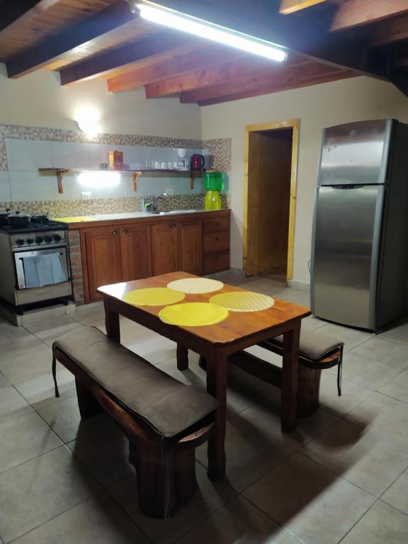 a kitchen with a wooden table and a stainless steel refrigerator at Los Acacios in El Hoyo