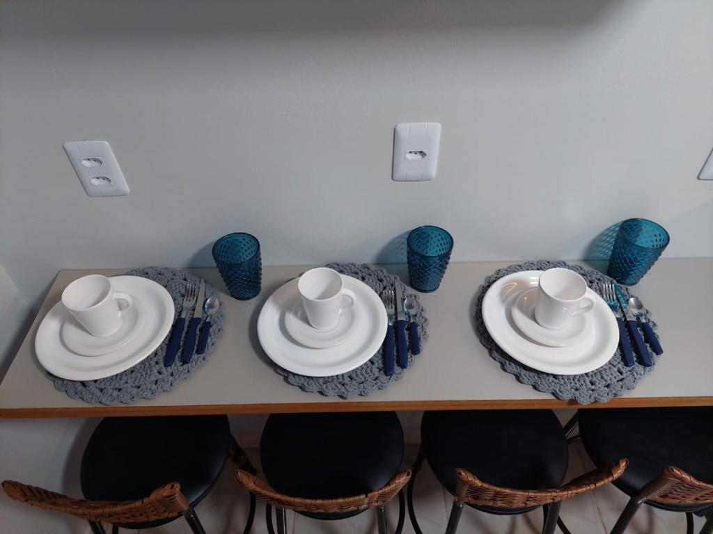 Suite Praia Parque في بنها: طاولة مع الأطباق والأكواب الزرقاء والأبيض