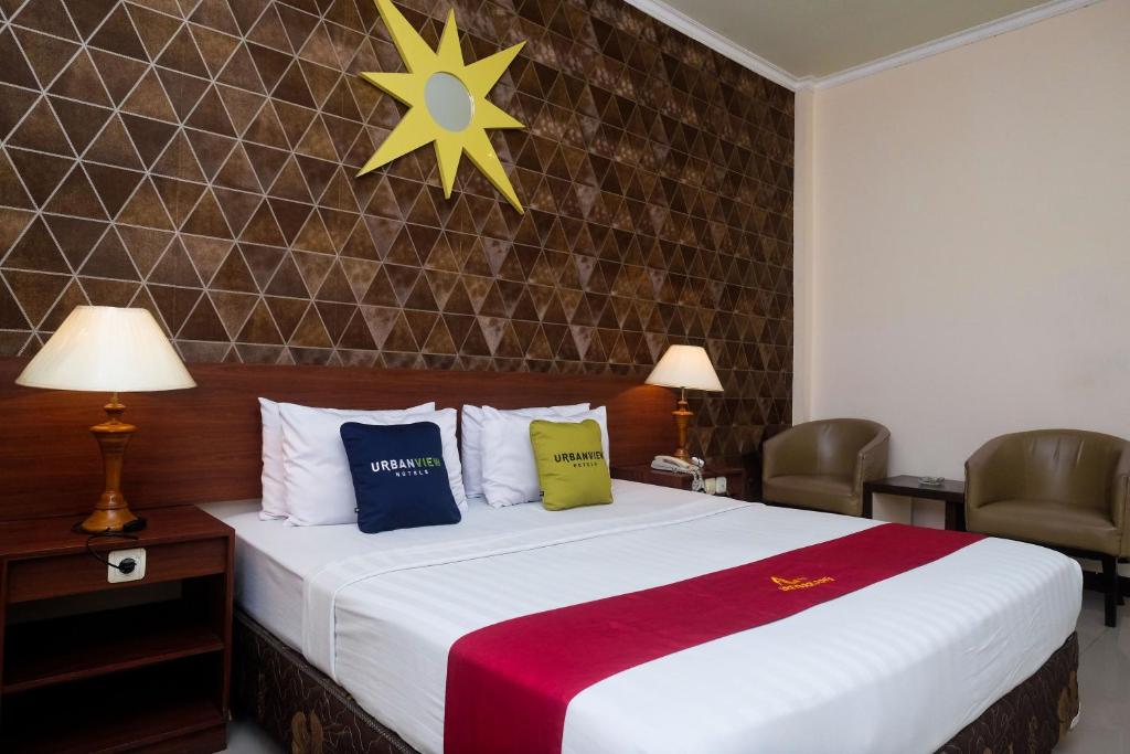 a hotel room with a bed with two pillows at UrbanView Hotel Anggraeni Jatibarang 