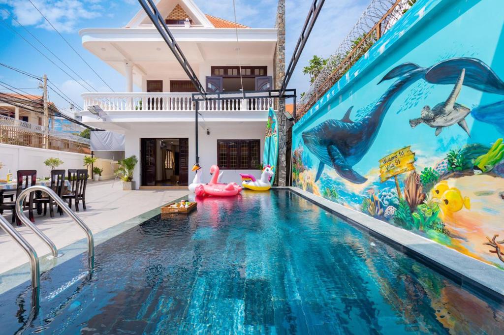 einem Pool mit Wandgemälde an der Seite eines Hauses in der Unterkunft Villa 91 VTS - Gần Biển Thùy Vân - Sân Rộng Đãi Tiệc - BIDA - KARAOKE FREE in Vũng Tàu