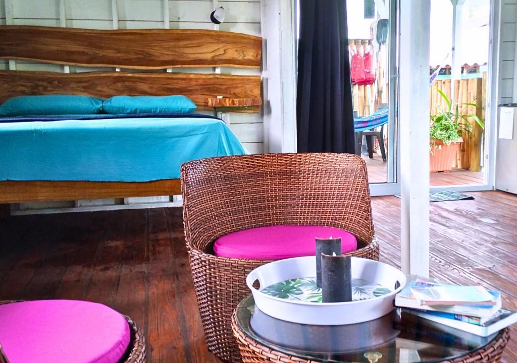 a room with a bed and a chair and a table at Coco Key EcoLodge - Breakfast - Sea in Bocas del Toro