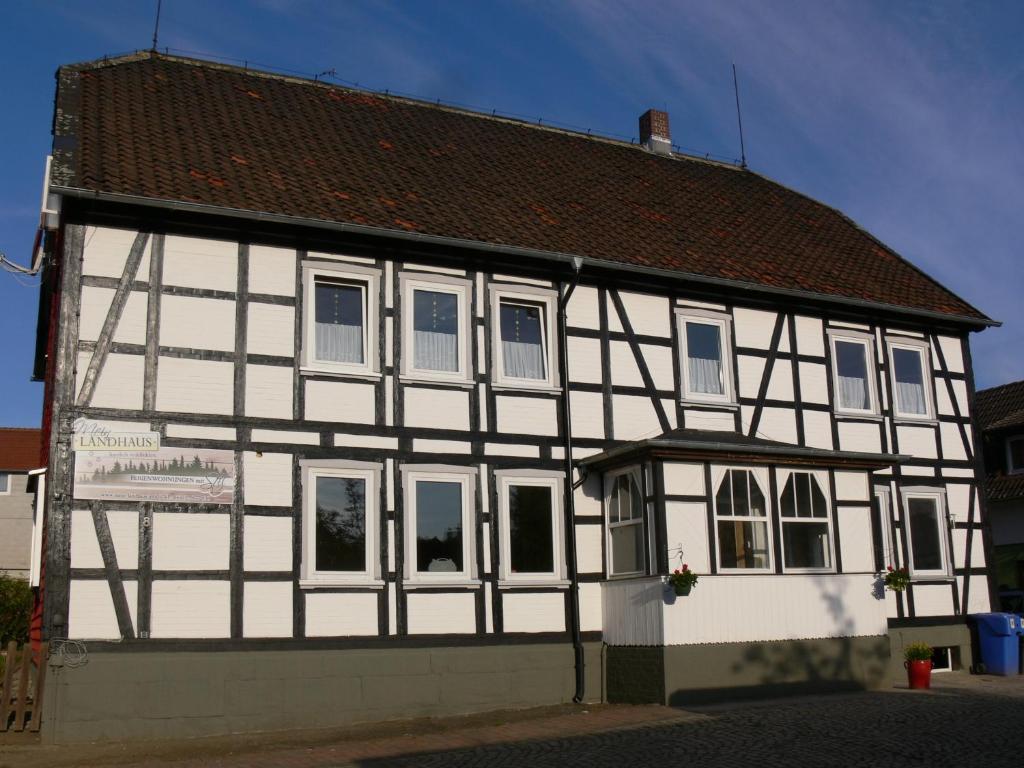ein weißes und schwarzes Gebäude mit einem braunen Dach in der Unterkunft Mein Landhaus Kleine Ferienwohnung in Bad Harzburg