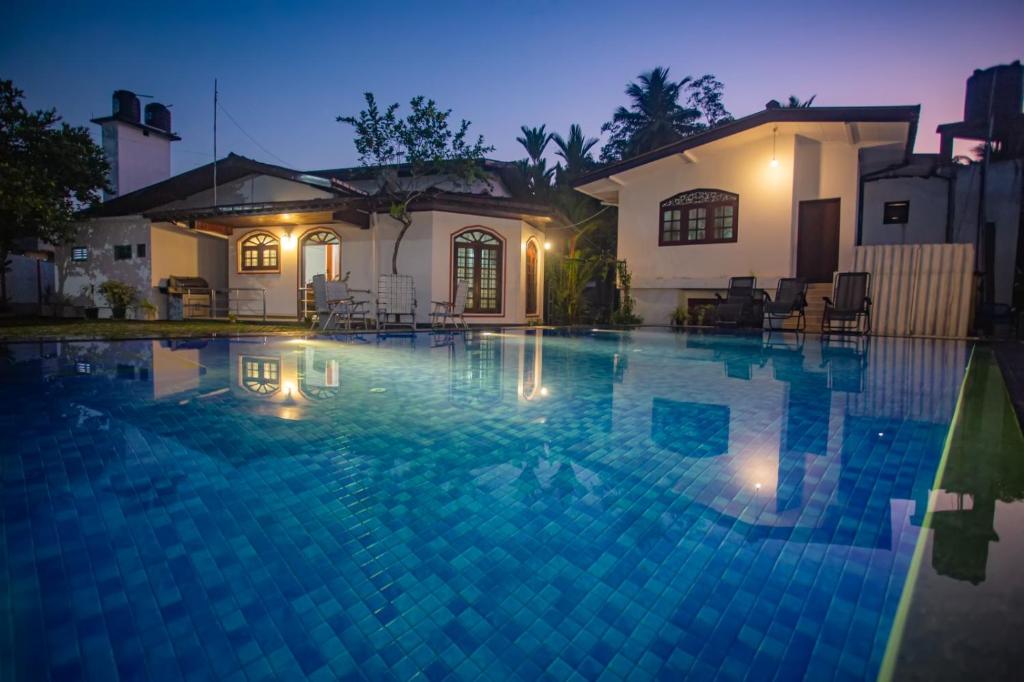 ein Schwimmbad vor einem Haus in der Nacht in der Unterkunft Villa 6070 in Galle