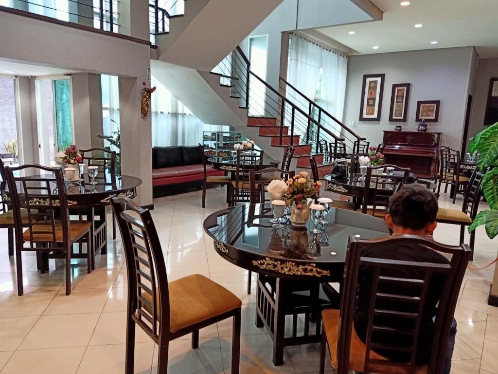 una persona sentada en una mesa en un restaurante en Surya Palace Syariah en Padang