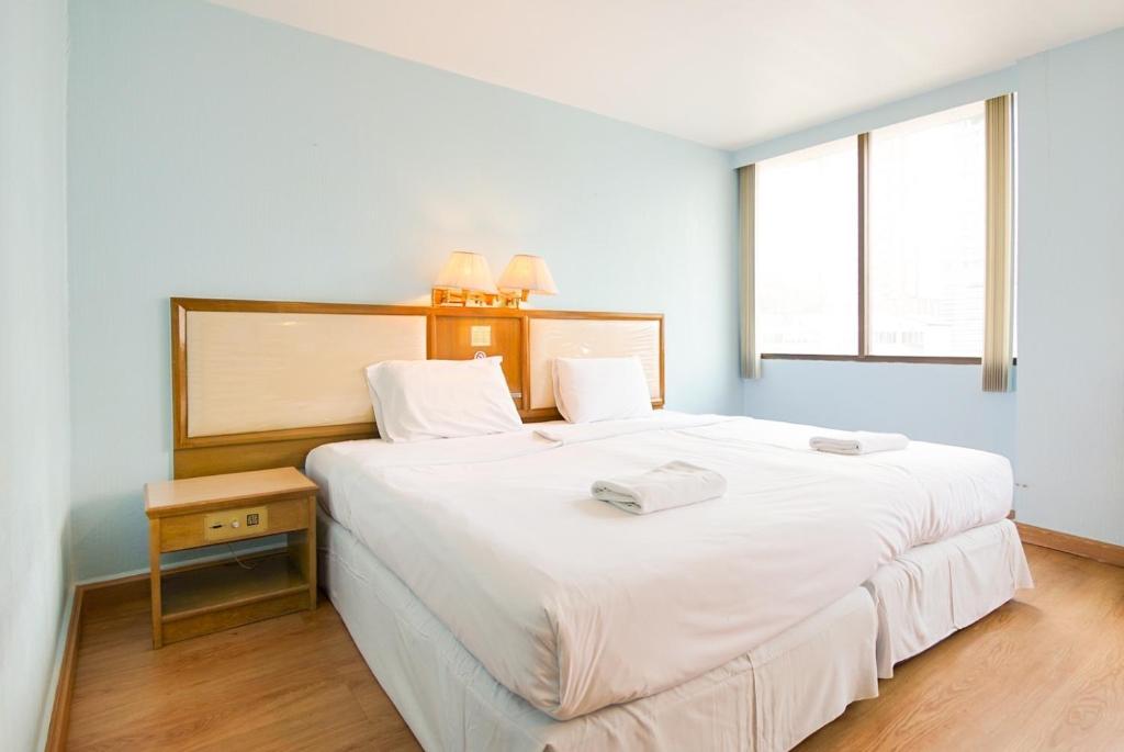 um quarto com uma grande cama branca com duas toalhas em Wish Inn Ratchaprasong - Chidlom วิช อินน์ ราชประสงค์ ชิดลม em Makkasan