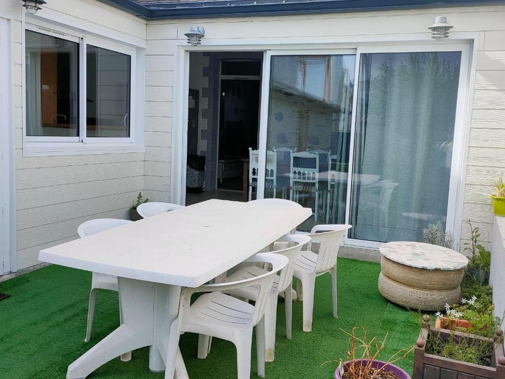 une table blanche et des chaises sur une terrasse dans l'établissement Maison Familiale de Charme à 300m de la Plage - Saint Jean de Monts, 6 Pers, Wifi Gratuit - FR-1-323-408, à Saint-Jean-de-Monts