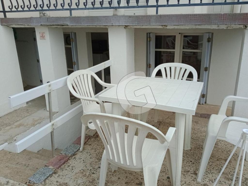 una mesa blanca y sillas en un porche en Appartement La Tranche-sur-Mer, 2 pièces, 3 personnes - FR-1-357-317, en La Tranche-sur-Mer