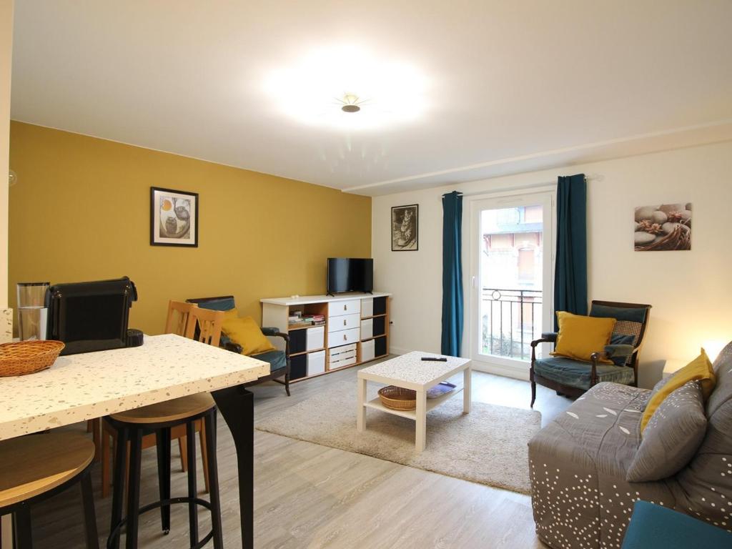 un salon avec un canapé et une table dans l'établissement Bel Appartement T3 Rénové avec Wi-Fi à 400m des Thermes de La Bourboule, Capacité 4 Personnes - FR-1-608-261, à La Bourboule