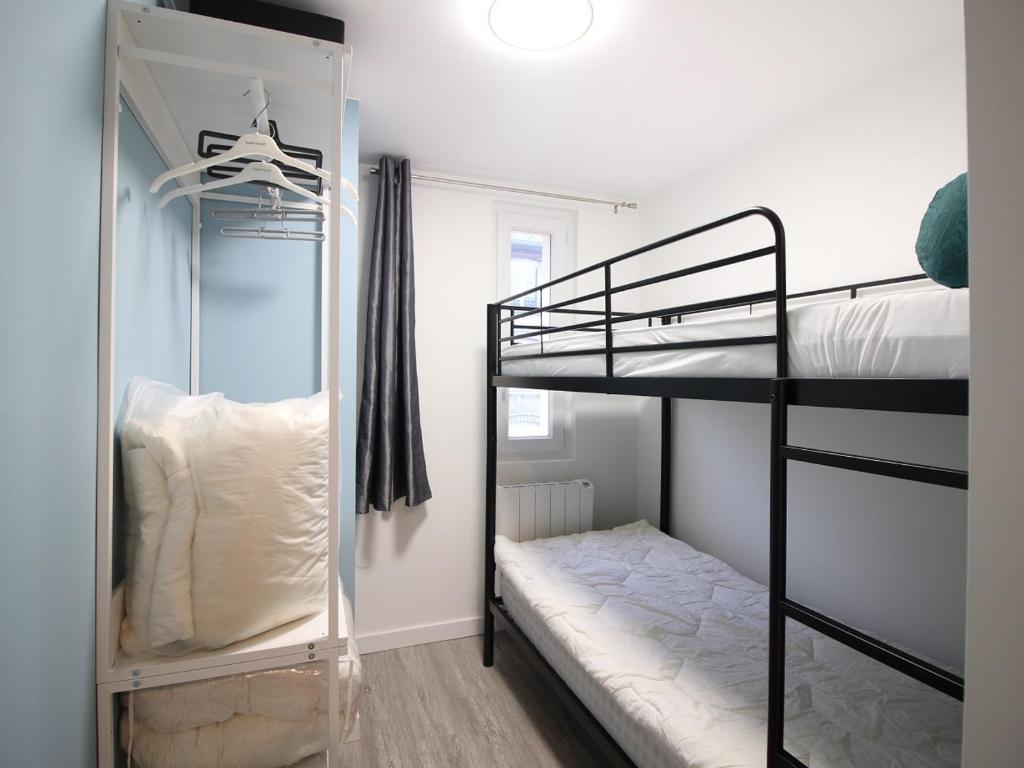 a bedroom with two bunk beds and a mirror at Appartement La Bourboule, 3 pièces, 4 personnes - FR-1-608-261 in La Bourboule