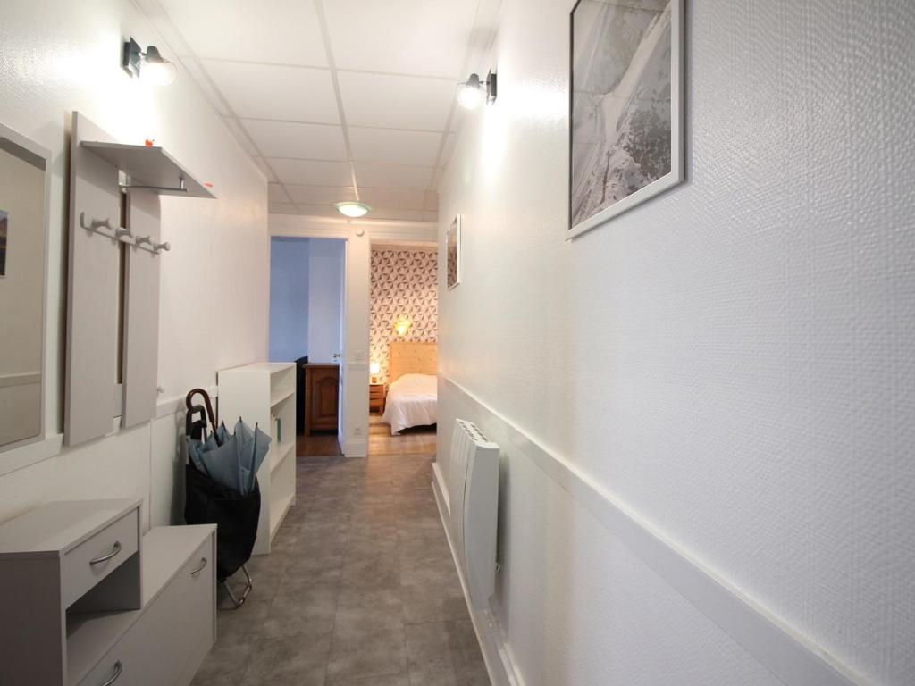 un couloir aux murs blancs et une chambre avec un lit dans l'établissement Confortable T3 avec Wi-Fi à 200m des thermes - 5 couchages max - FR-1-608-260, à La Bourboule