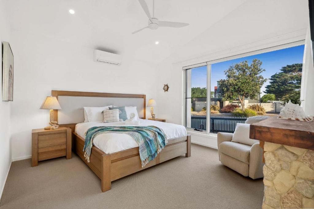 a bedroom with a bed and a large window at Bella Beach Resort - An Oasis on the Bellarine with heated pool in Saint Leonards