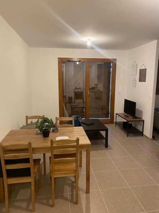 a living room with a wooden table and chairs at T2 pied de piste + Parking in Les Déserts