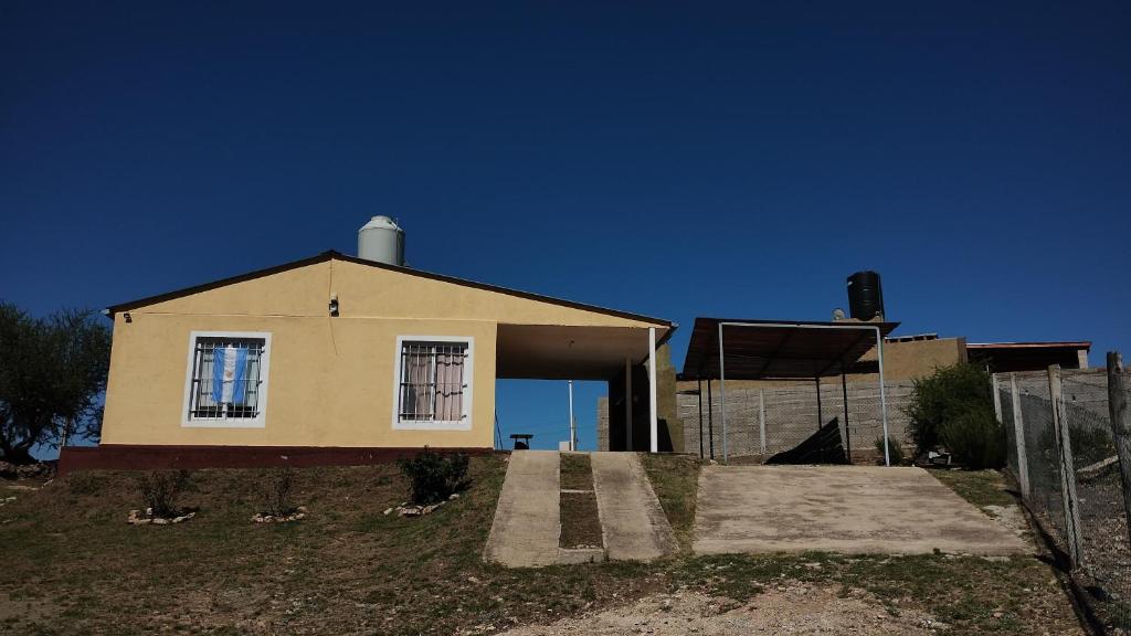 a house on top of a hill with a fence at El Roble, casa de sierra in Estancia Vieja