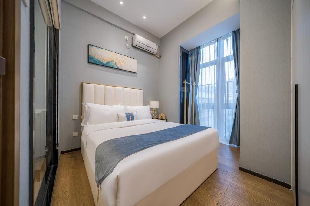 Postel nebo postele na pokoji v ubytování Gepai Executive Apartment - Shenzhen Futian Convention and Exhibition Center