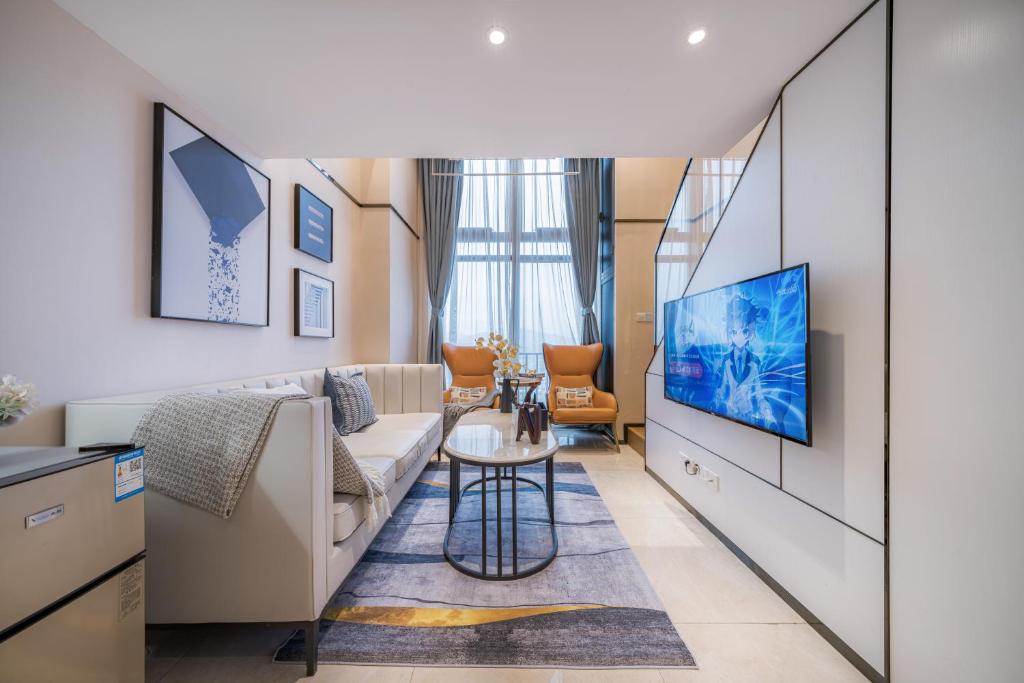 a living room with a couch and a tv at Gepai Executive Apartment - Shenzhen Futian Convention and Exhibition Center in Shenzhen