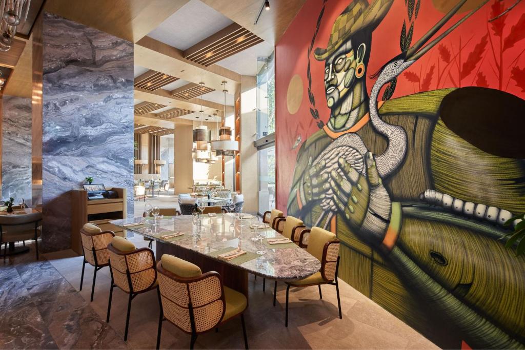 JW Marriott Hotel Mexico City Polanco في مدينة ميكسيكو: مطعم فيه لوحة كبيرة على الحائط