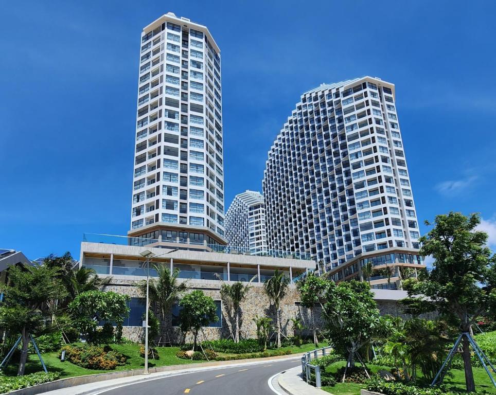 two tall buildings in a city with a road at Apec Mandala Mũi Né Condotel By Vũ in Mui Ne