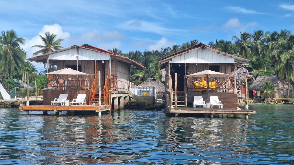 dos casas en el agua con sillas. en Cabañas Narasgandup (Naranjo Chico), en Mamartupo