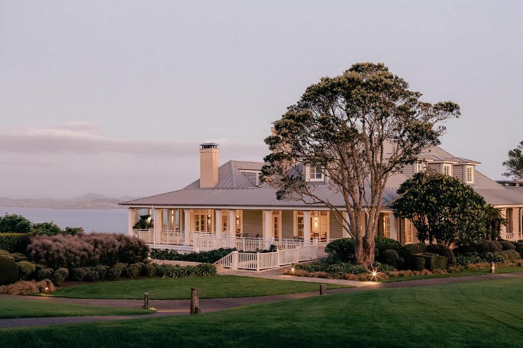 ein großes Haus mit einem Baum davor in der Unterkunft Rosewood Kauri Cliffs in Matauri Bay