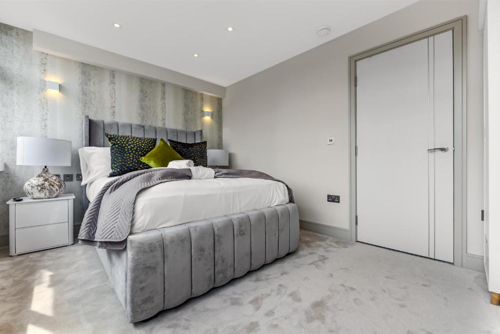 ロンドンにある1 Bedroom stylish apartment in Webley parkの白いベッドルーム(大型ベッド1台、スライドドア付)