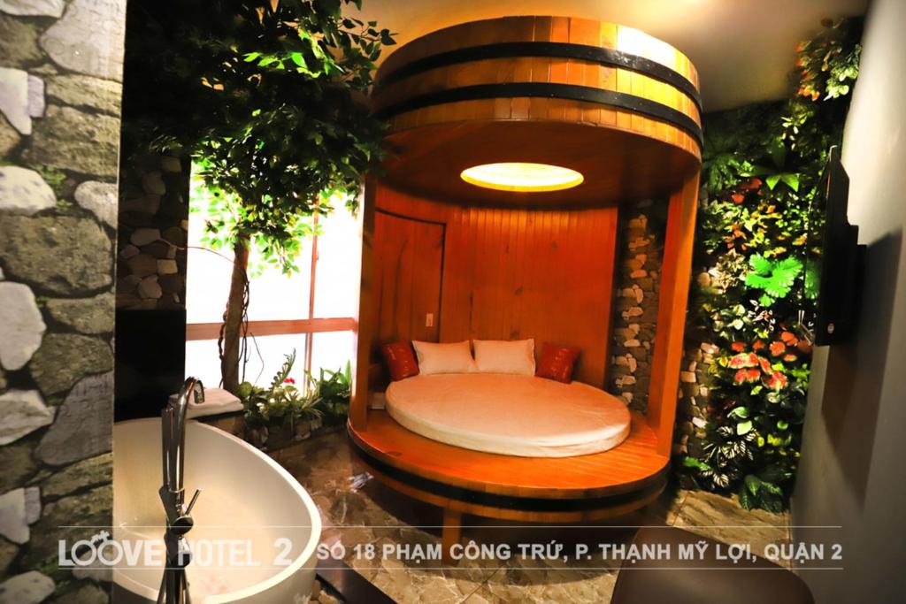 Cama pequeña en baño con lavabo en Loove Hotel - Khách Sạn Tình Yêu en Ho Chi Minh