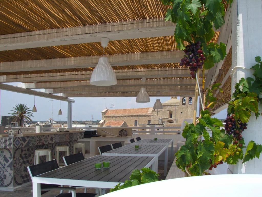 een patio met een tafel en stoelen en een gebouw bij B&B Luvì in Maruggio