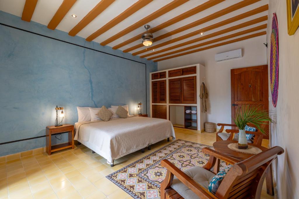 a bedroom with a bed and a blue wall at Casa Pakal Valladolid in Valladolid