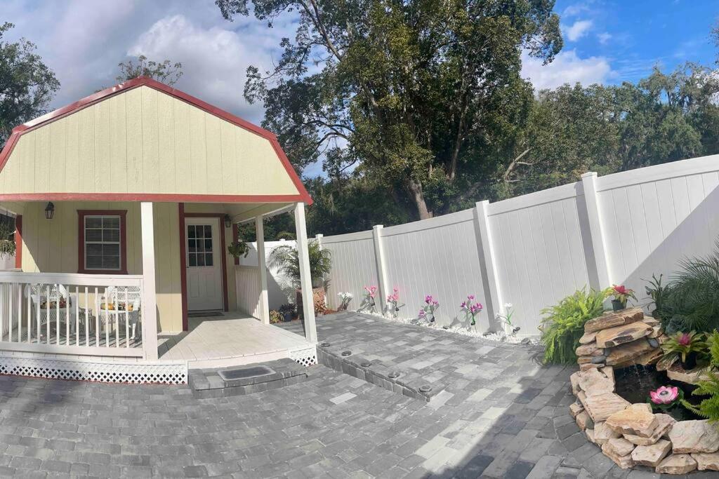 een klein huis voor een wit hek bij The Tiny Cottage in the Springs/ Central FL in Orlando
