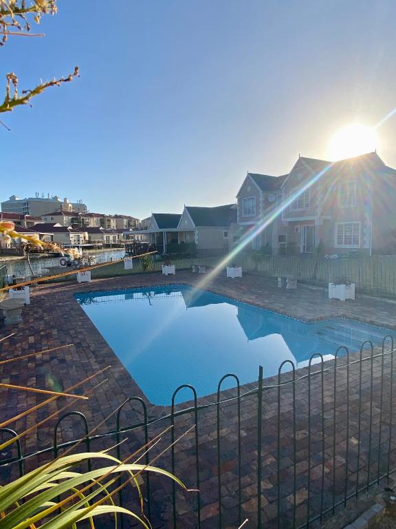 a reflection of a house in a swimming pool at Claptons Cottage 12 in Jeffreys Bay