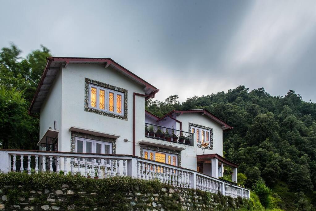 a white house with a balcony on a hill at The White Peaks in Nainital