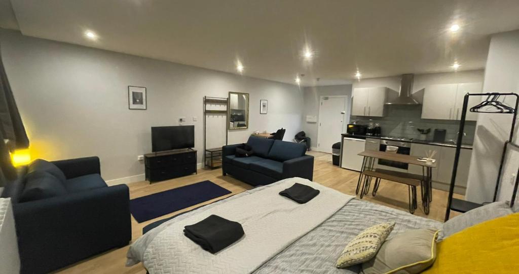 ein Wohnzimmer mit einem Bett und einer Küche in der Unterkunft Market Haven Deluxe Studios Town centre with Netflix, Business & Leisure Travellers in Northampton
