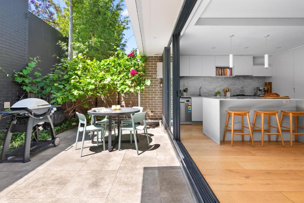 an open kitchen and dining room with a table and chairs at 4 bedrooms family home in Bronte in Sydney