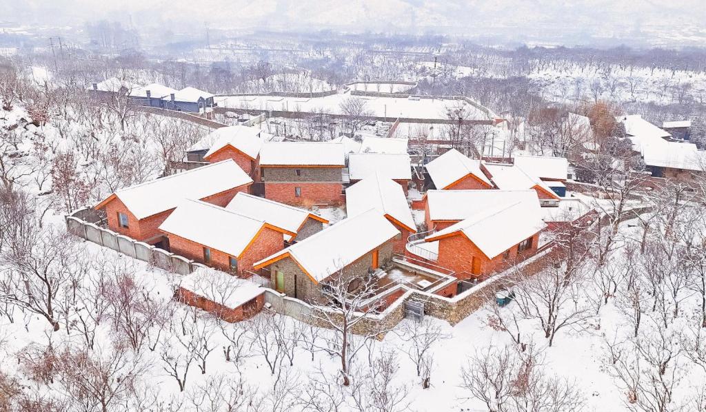 an aerial view of a house covered in snow at Sansa Village Boutique Hotel at Mutianyu Great Wall in Huairou