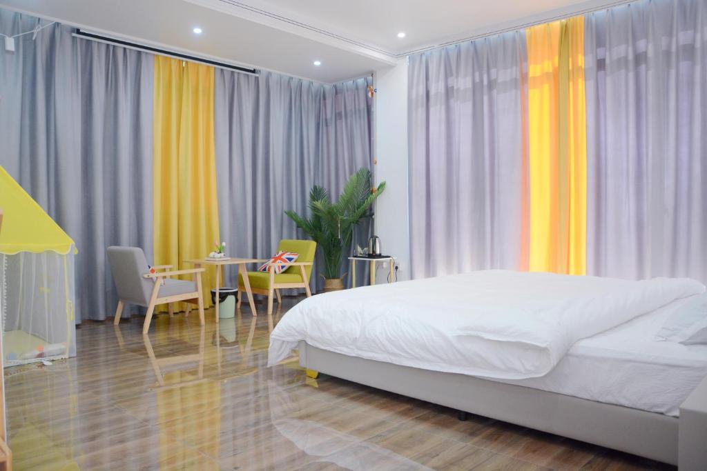 een slaapkamer met een bed en een tafel en stoelen bij Banyan Bay Homestay, Meizhou Island in Meizhou