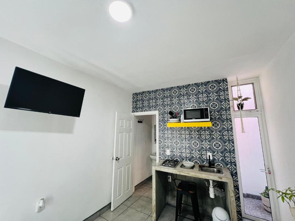 a kitchen with a sink and a microwave on a wall at CASA AMBAR in Tijuana