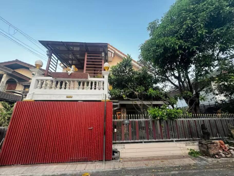 una recinzione rossa di fronte a una casa di 曼谷独栋Lat Phrao精品别墅 a Ban O Pao