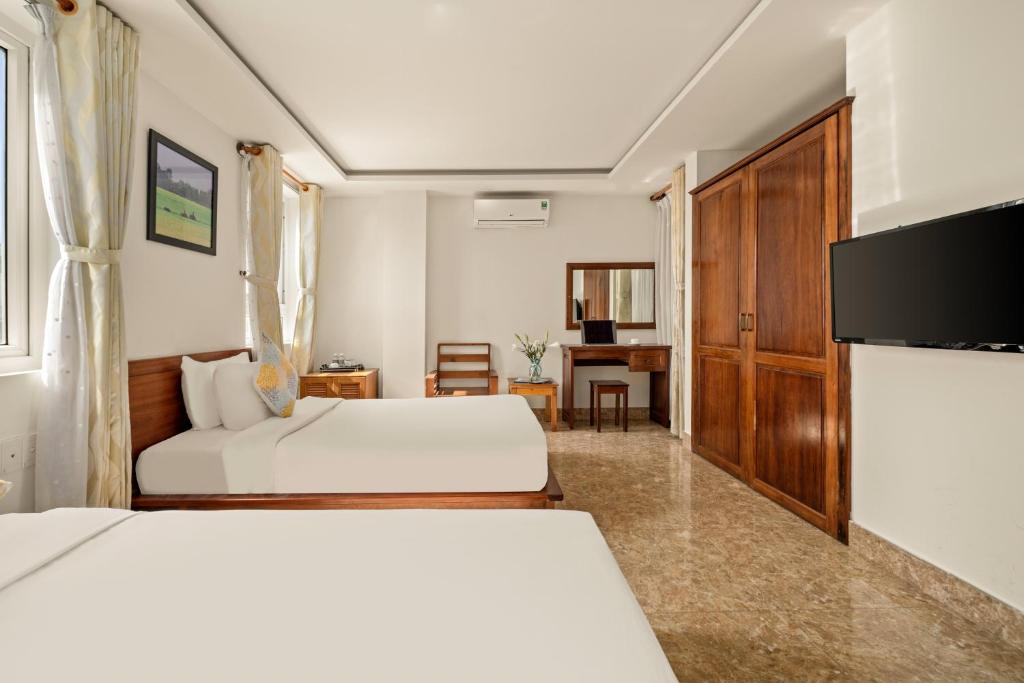 Postel nebo postele na pokoji v ubytování Titan Hotel Da Nang